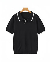 Black polo shirt with white trim on a wooden hanger against a white background