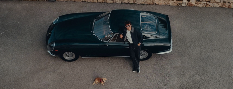 Stedford model standing next to a vintage car with a dog
