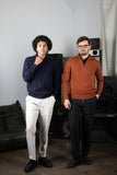 Two Stedford model standing in a room with speakers and a gray wall.