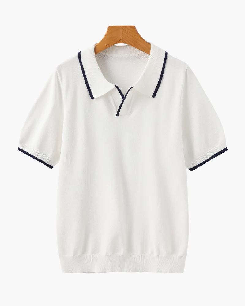 White polo shirt with black trim on a wooden hanger against a white background