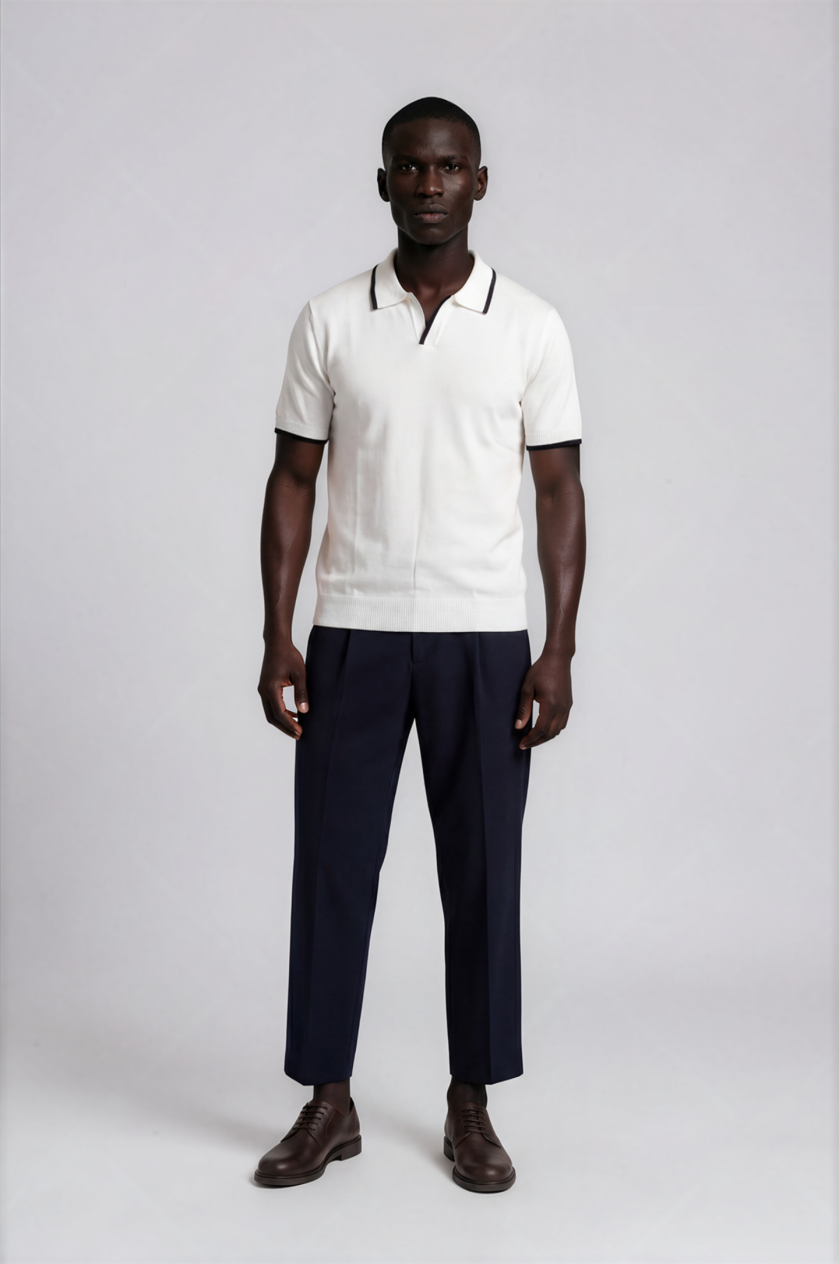 Man wearing a white polo shirt and navy pants on a white background