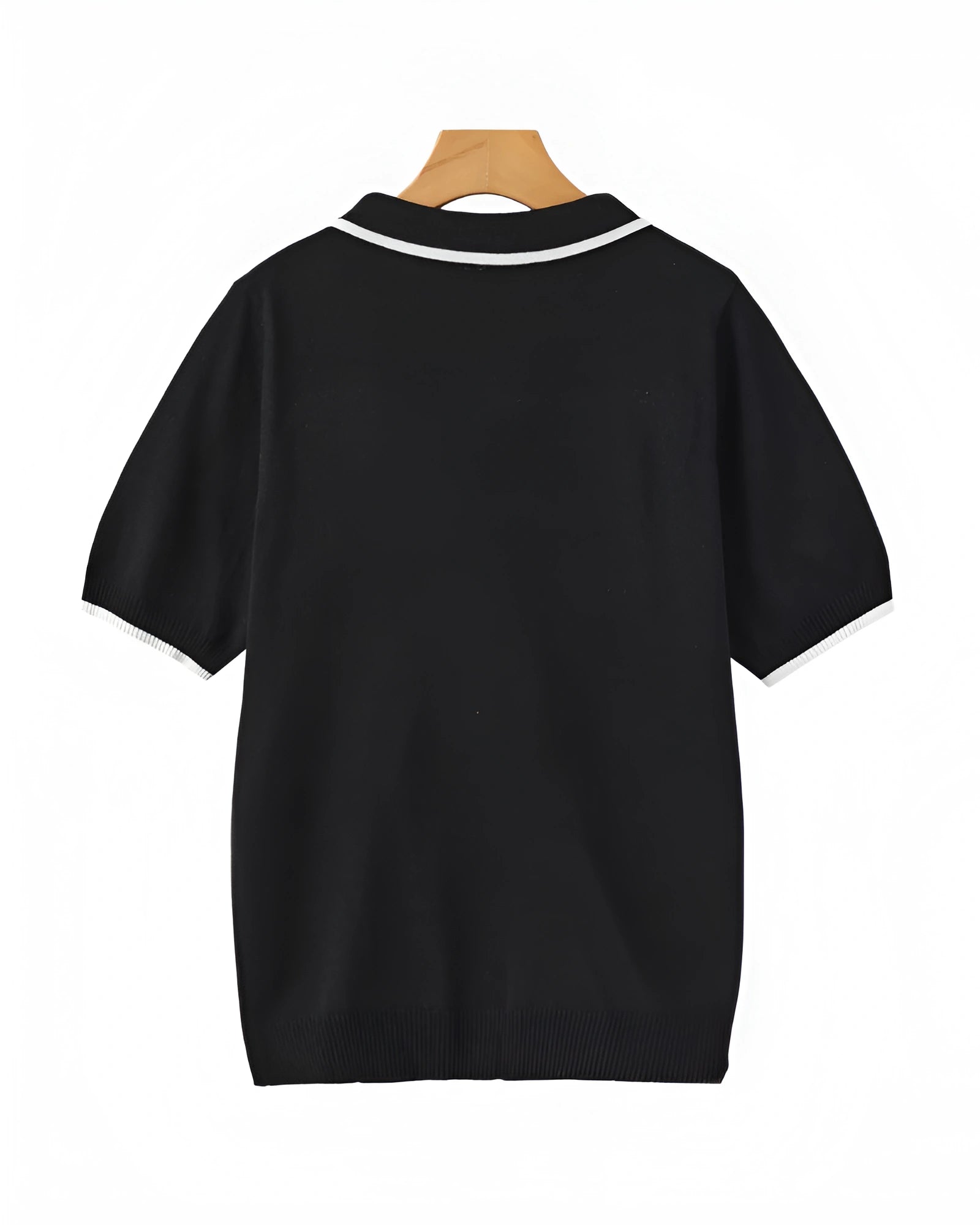 Black polo shirt on a wooden hanger with a white background