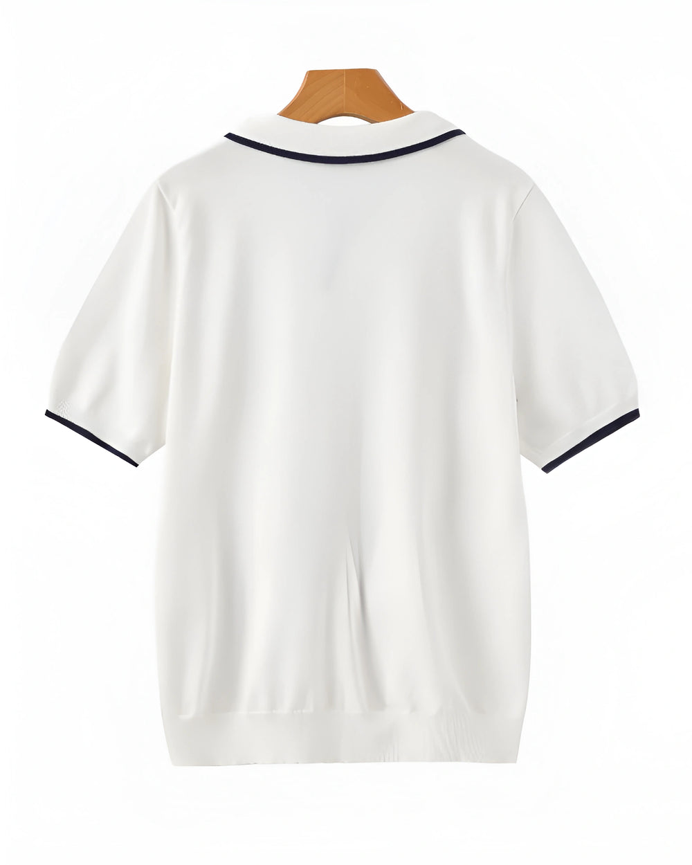 White polo shirt with black trim on a wooden hanger against a white background